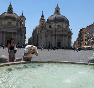 Un hombre se refresca la cabeza en una plaza de Italia Un hombre se refresca la cabeza en una plaza de Italia