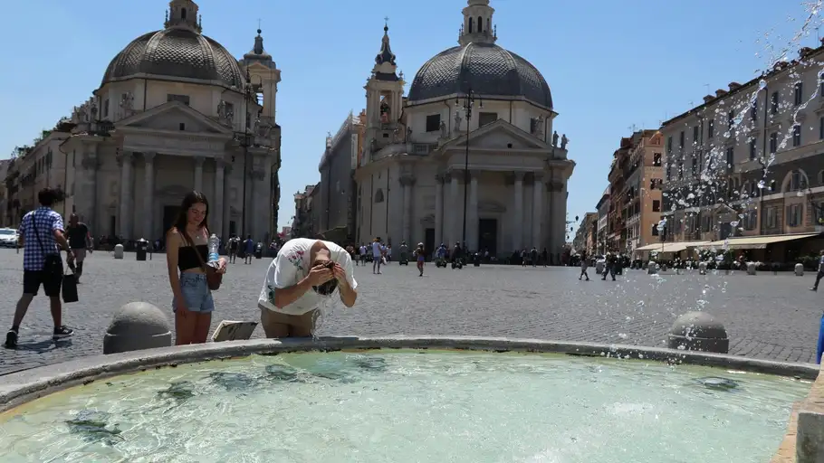 Un hombre se refresca la cabeza en una plaza de Italia Un hombre se refresca la cabeza en una plaza de Italia
