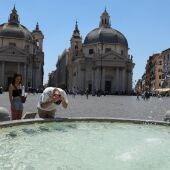 Un hombre se refresca la cabeza en una plaza de Italia