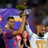 El capitán del FC Barcelona Sergio Busquets posa con la copa junto al exjugador Dani Alves