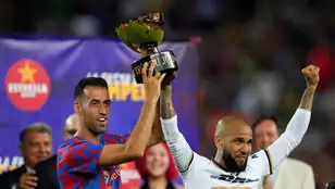 El capitán del FC Barcelona Sergio Busquets posa con la copa junto al exjugador Dani Alves