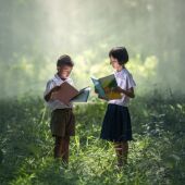 Niños leyendo en medio del bosque