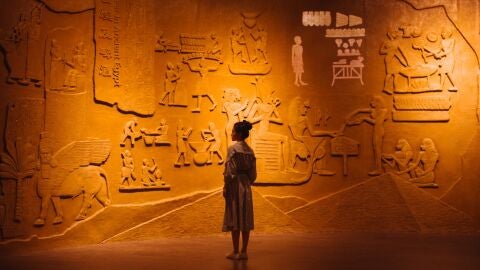 Imagen de una mujer observando grabados arqueol&oacute;gicos