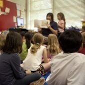 Un grupo de niños atiende a la lectura de un libro en una imagen de archivo