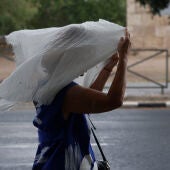 Una mujer se tapa la cabeza con una tela debido a la lluvia