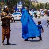 Tropas talibanes en Afganistán vigilando a una mujer con un burka (archivo)