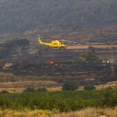 Un helicóptero participa en las laboras de extinción del incendio en Añón del Moncayo, Zaragoza, este domingo.