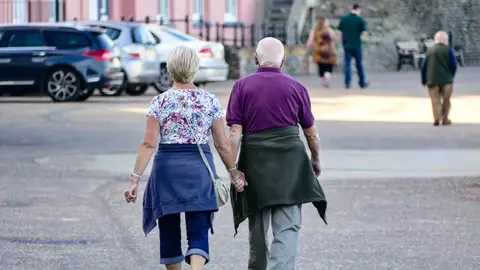 Imagen de archivo de una pareja de jubilados caminando de la mano