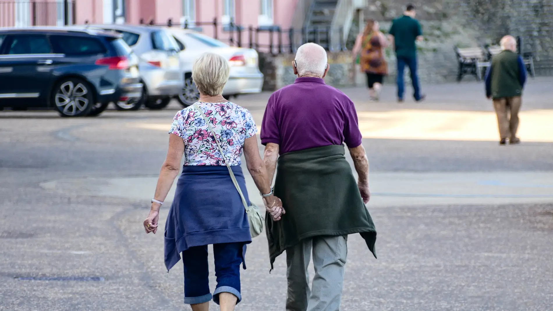 Imagen de archivo de una pareja de jubilados caminando de la mano/ Unsplash