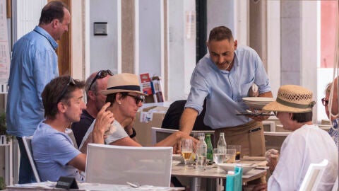 Un camarero sirve varias bebidas en una terraza en la localidad menorquina de Mahón.