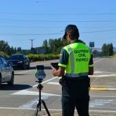 Un agente de la Guardia Civil con un radar en la carretera