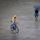 Dos personas se protegen de la fina lluvia, este lunes