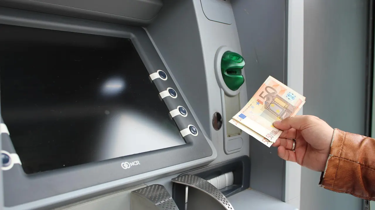 Una persona se dispone a ingresar dinero en un cajero, en una imagen de archivo