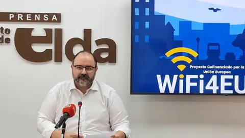 Jesús Sellés, concejal de Modernización de Elda, junto al cartel de la campaña Wifi4EU.