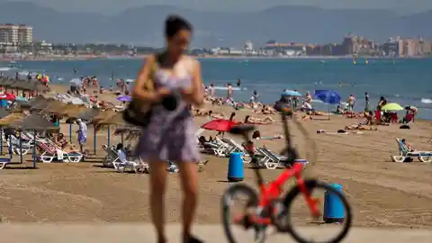 Turistas en una playa valenciana, en imagen de archivo. 