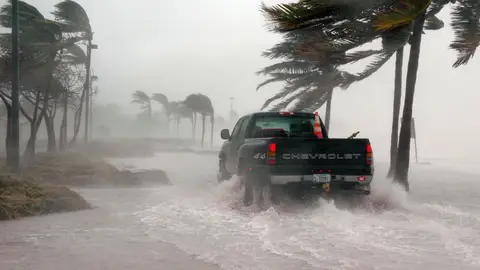 Un coche atraviesa una carretera inundada por el paso de un huracán en Cayo Hueso, Florida