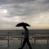 Un hombre se protege con el paraguas de la lluvia.