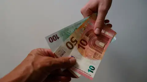 Foto de archivo de unos billetes de euro en las manos. 
