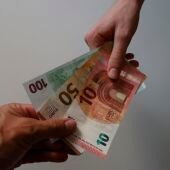 Foto de archivo de unos billetes de euro en las manos. 
