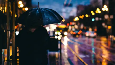 Una persona protegiéndose de la lluvia