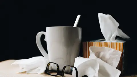 Una imagen de archivo que muestra una taza, una caja de pañuelos y unas gafas
