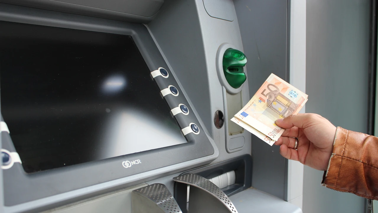 Una persona sacando dinero del cajero