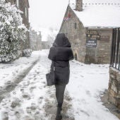 Una persona pasea por la calle en una zona nevada.