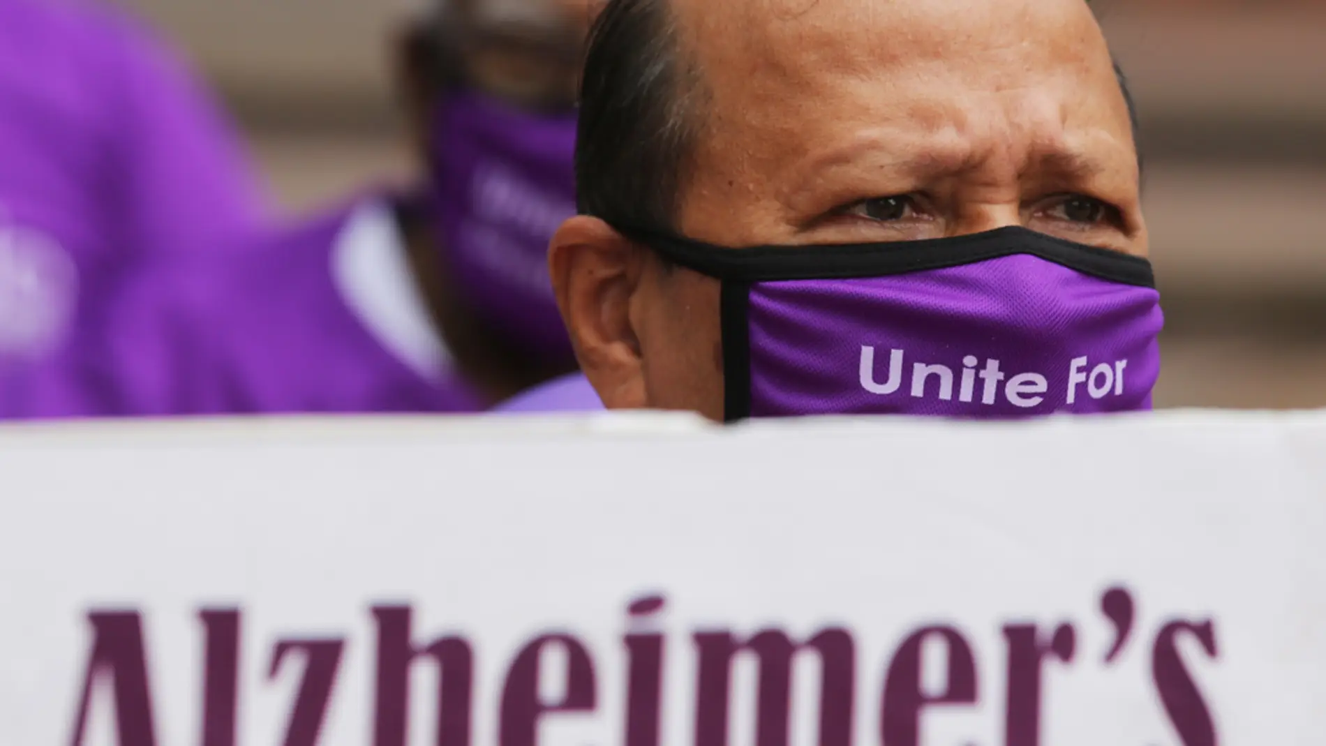 Una persona con una máscara púrpura sostiene una pancarta durante una reunión en el 'Día Mundial del Alzheimer'/ EFE/EPA/JAGADEESH NV