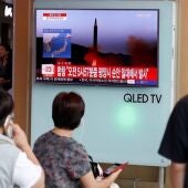 Ciudadanos japoneses escuchan y observan las últimas noticias sobre el misil lanzado por Corea del Norte.