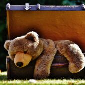Imagen de archivo de una maleta abierta con un oso de peluche