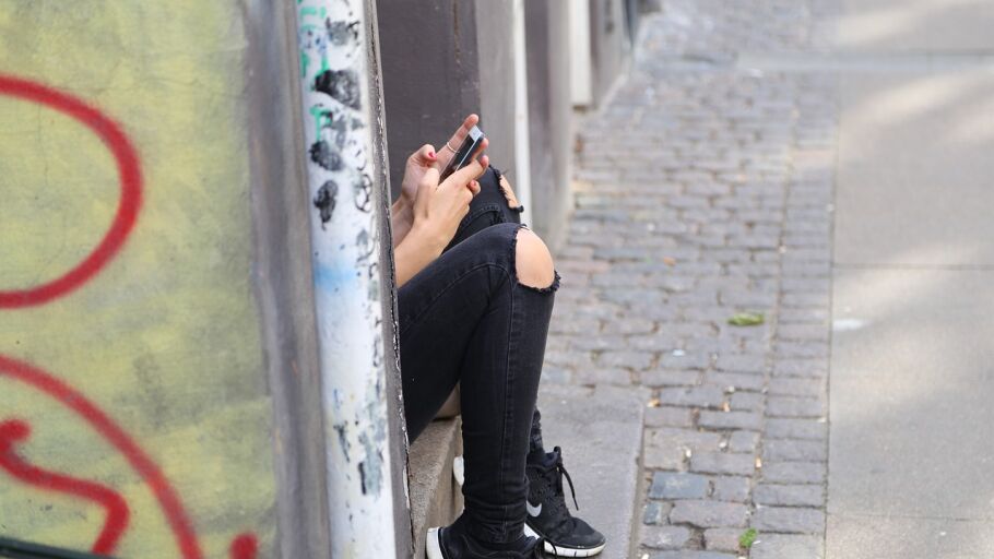 Una adolescente mira su tel&eacute;fono m&oacute;vil