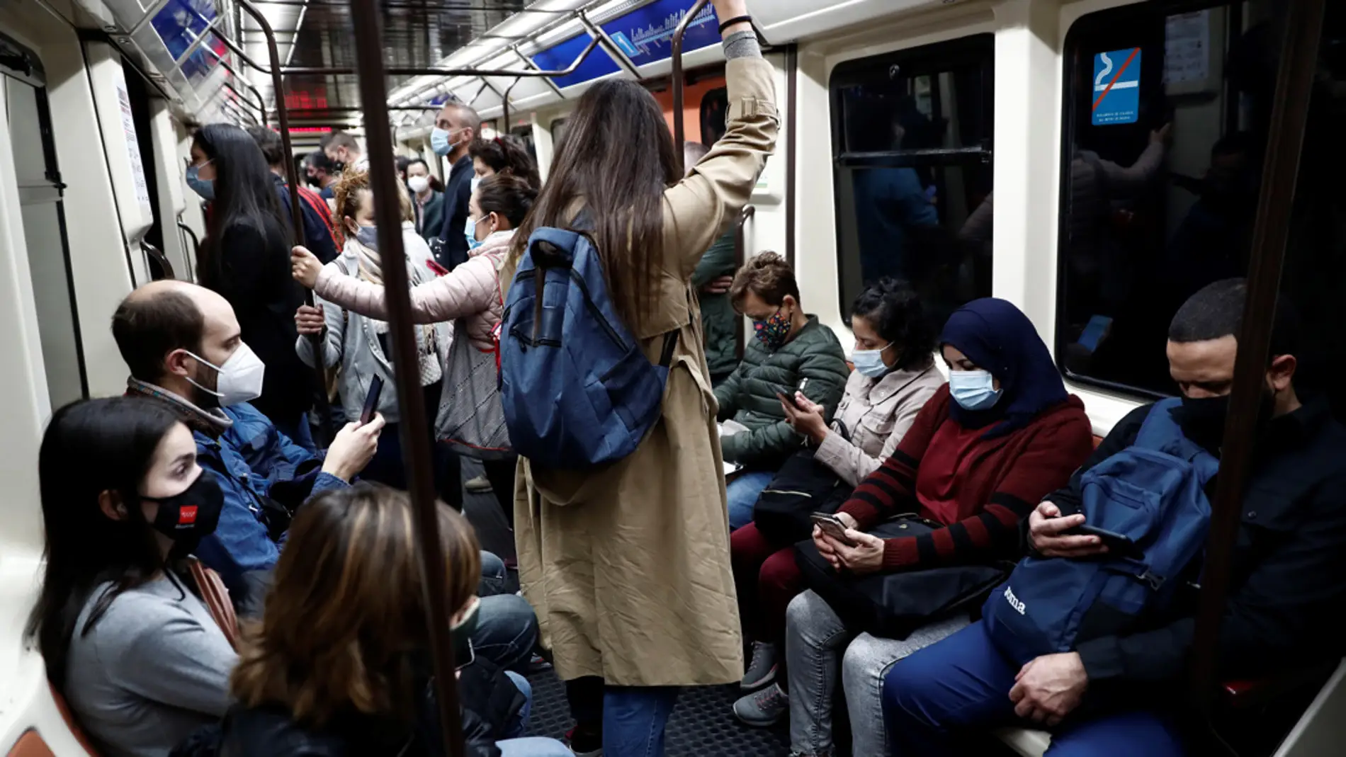 Un grupo de personas viajan en el Metro utilizando las mascarillas