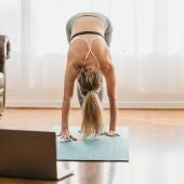 Una mujer realiza una posición de yoga en una imagen de archivo