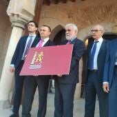 La Comisión de la Bandera de Badajoz presenta una bandera de color carmesí y 3 símbolos