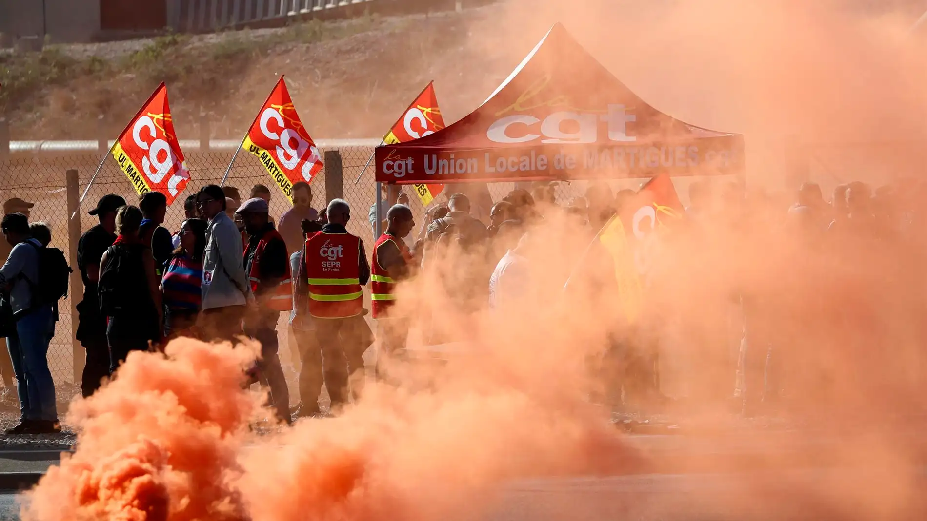 Trabajadores de TotalEnergies y Esso ExxonMobil lanzan una bomba de humo de colores durante una protesta
