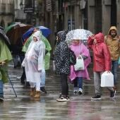 Turistas y peregrinos se protegen de la lluvia en Santiago de Compostela.