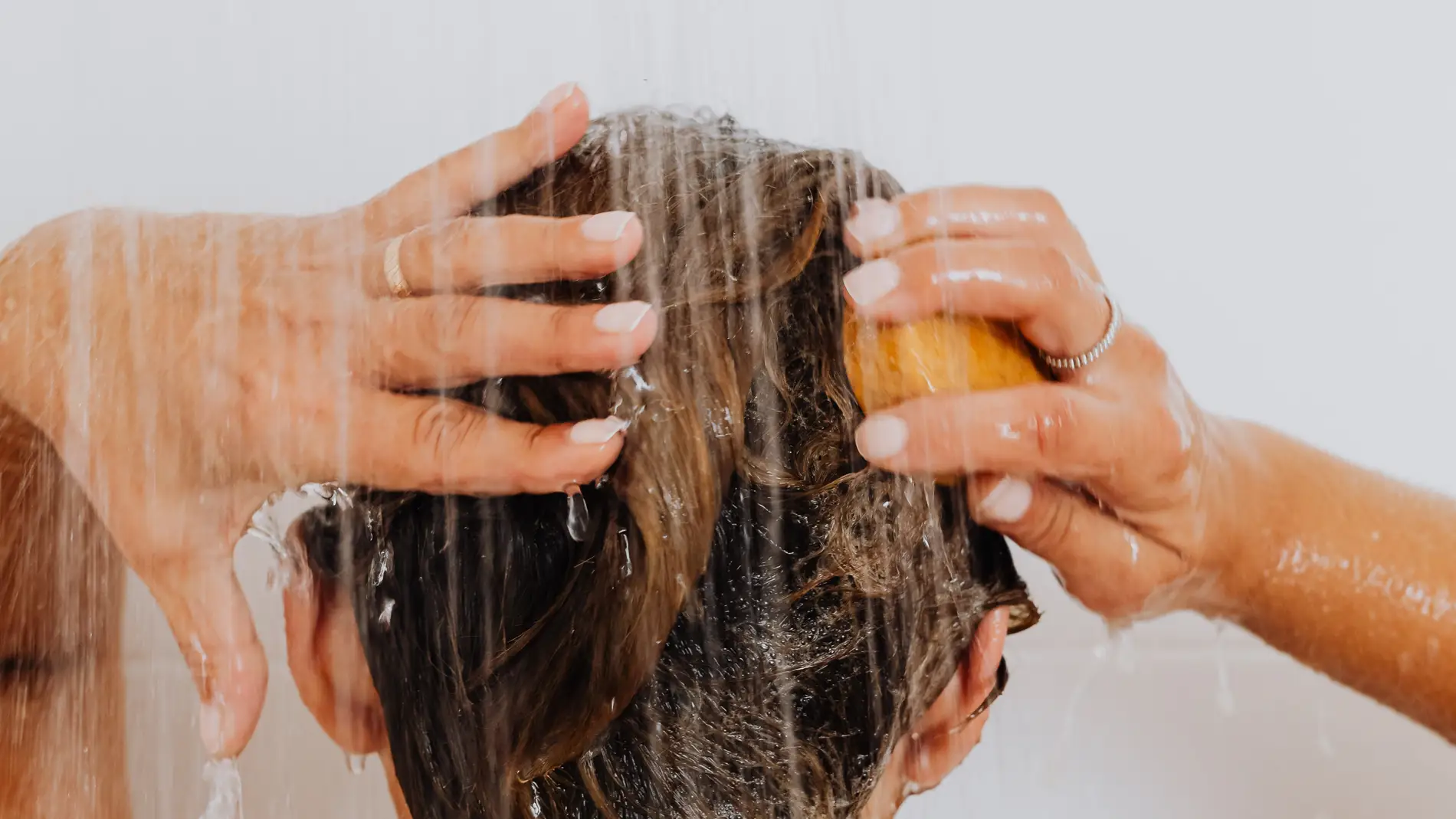 Una mujer lavándose el pelo