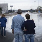 Varias personas observan un tramo de la autovía del Este, A-3, inundada, a 12 de noviembre de 2022 - 