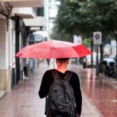 Una mujer pasea por la calle bajo la lluvia