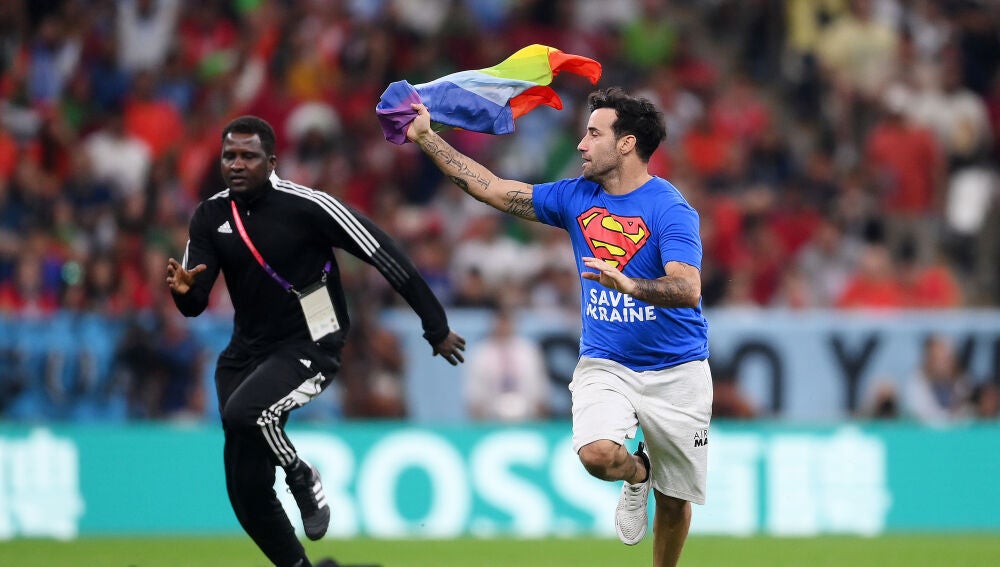 Un aficionado salta al Portugal - Uruguay con una bandera arcoiris