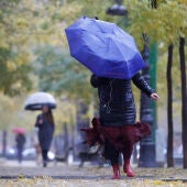 Una mujer caminando con paraguas