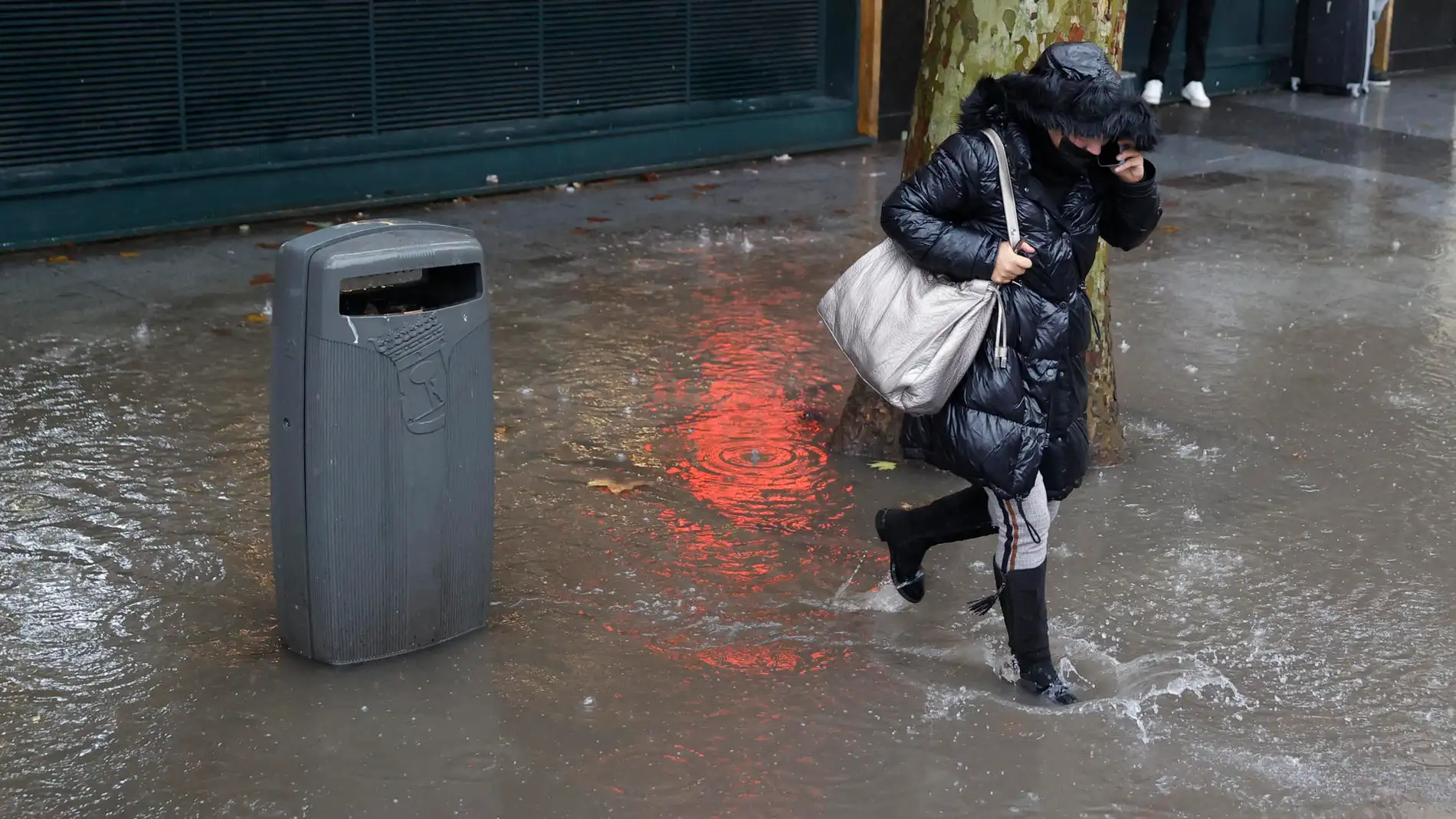Una mujer corre para protegerse de la lluvia