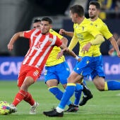 El centrocampista del Almería Lucas Robertone juega un balón ante varios jugadores del Cádiz