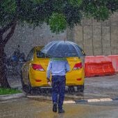 Imagen de archivo de un hombre caminando bajo la lluvia