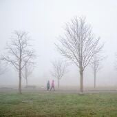 Dos mujeres pasean bajo la niebla en Vitoria