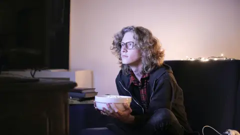 Una persona viendo la televisión Las cinco canciones usadas en anuncios más escuchadas de 2022