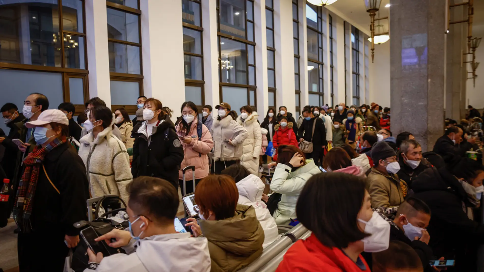 Decenas de ciudadanos chinos esperan en una estación de tren tras el final de la política 'Covid cero' del gobierno