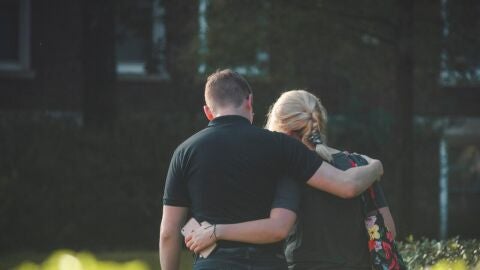 Una pareja abraz&aacute;ndose mientras pasea por la calle