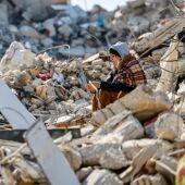 Una mujer se sienta este sábado entre los escombros producidos por el terremoto que asoló Turquía