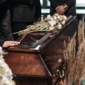 Familiares tocan el ataúd de un fallecido durante un funeral